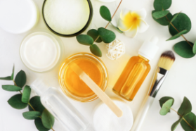 honey in bowl next to cosmetic bottle