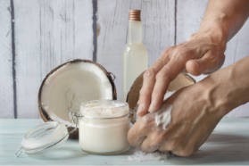 person rubbing cream from jar on hand