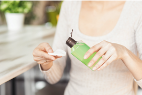 women squeezing makeup remover onto pad